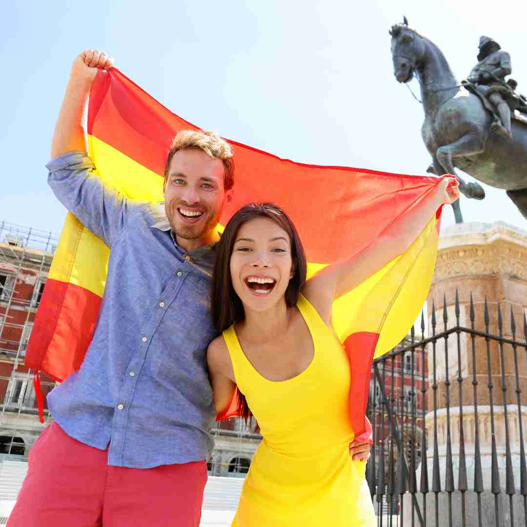 Pareja celebrando con la bandera española su nueva nacionalidad